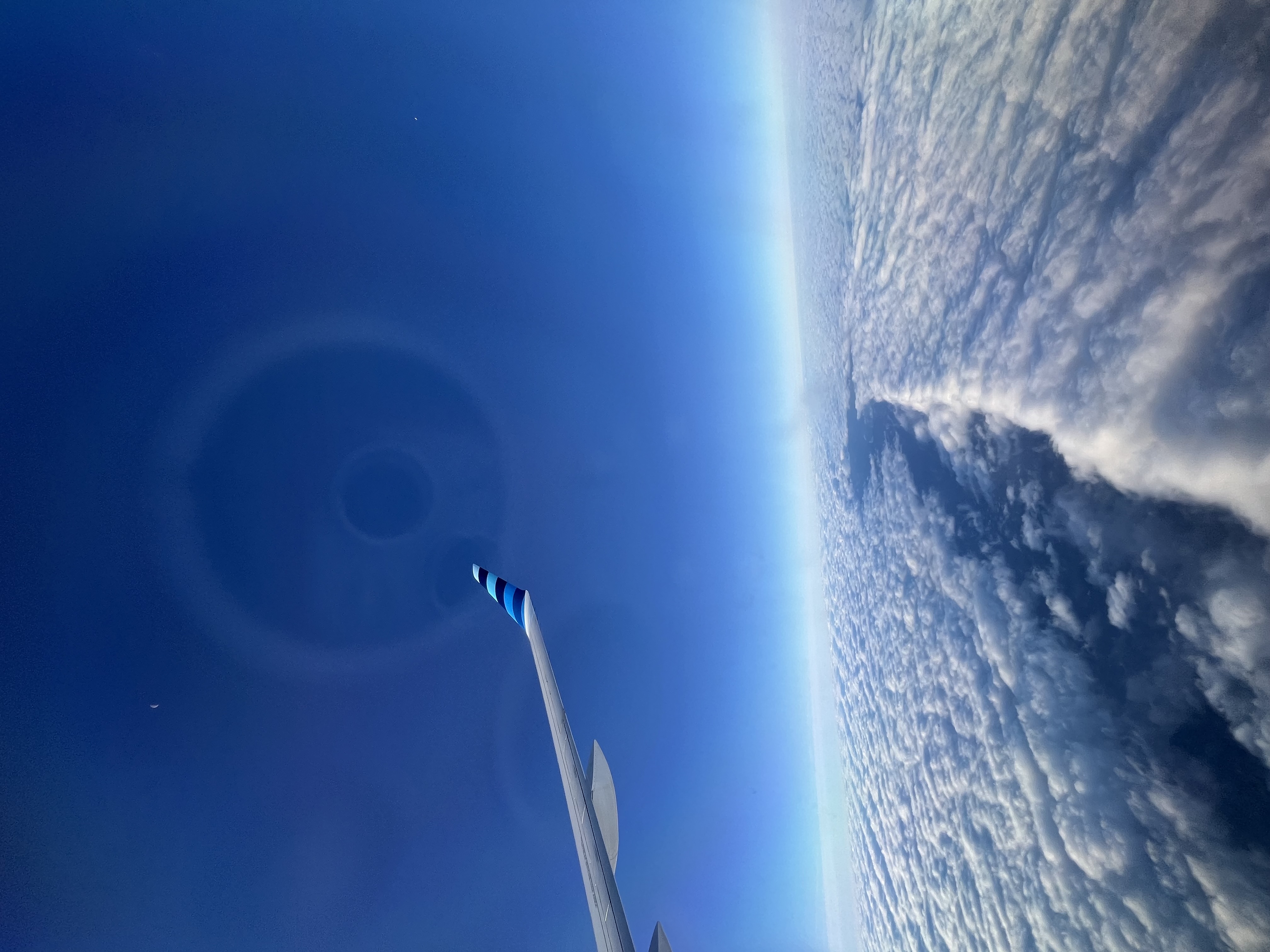 Airplane flying over cloud formation, November 2025